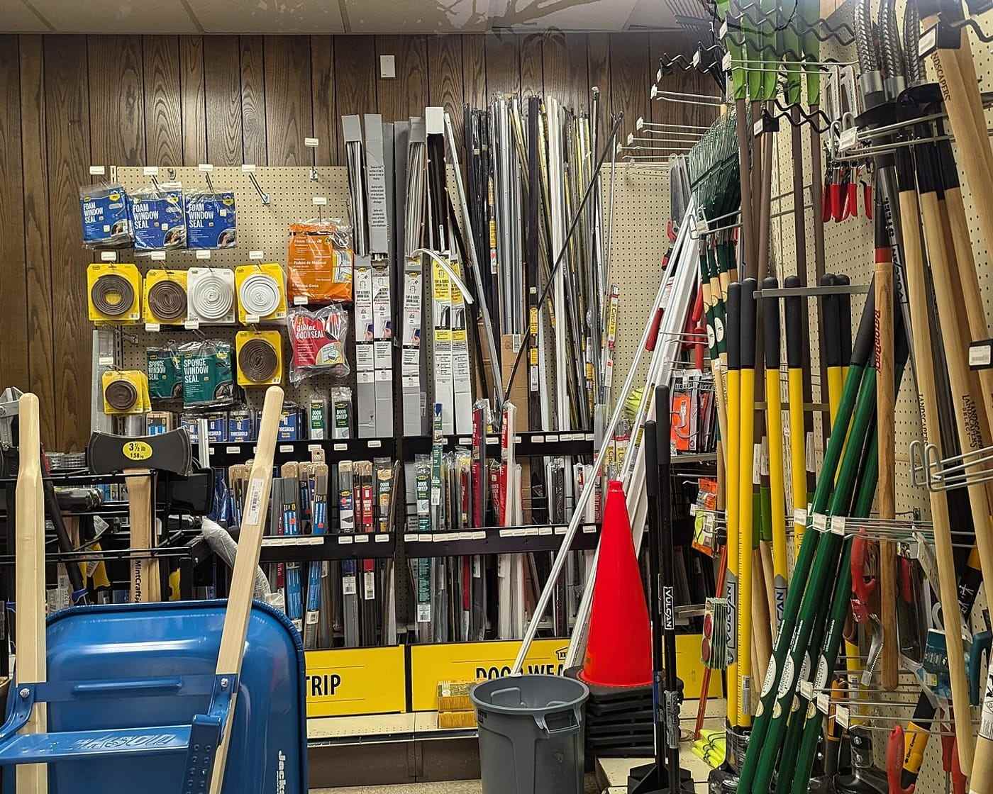 An aisle of hand tools, shovels and fasteners inside the store